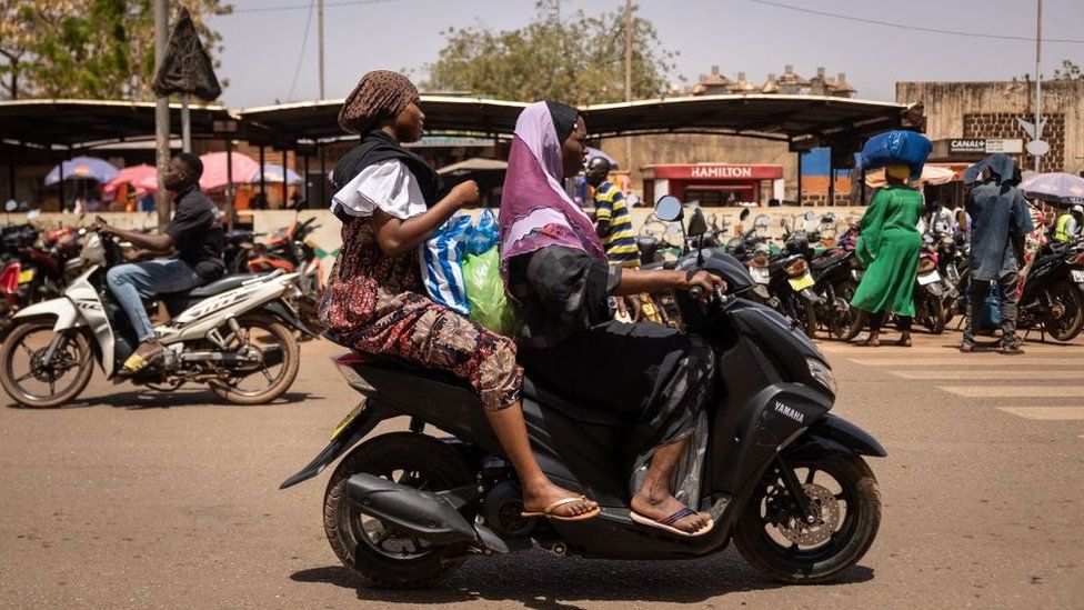 A woman rides a motorcycle in Ouagadougou
