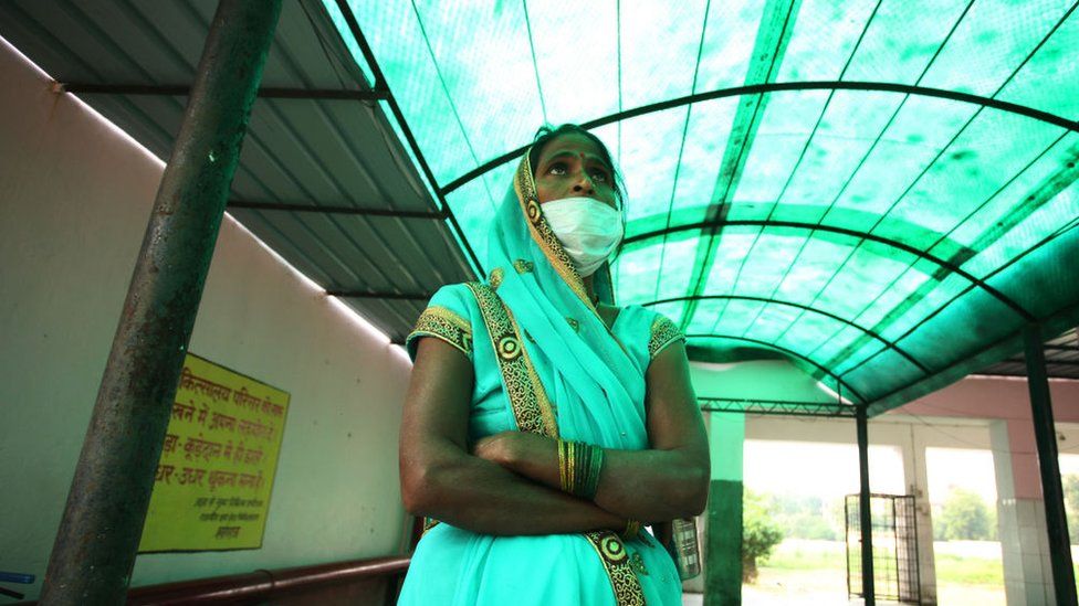 Relative of a patient suffering from Tuberculosis standing outside of a government hospital.