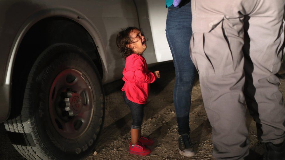 A two-year-old Honduran girl as her mother is searched and detained near the US-Mexico border on in McAllen, Texas, on 12 June 2018