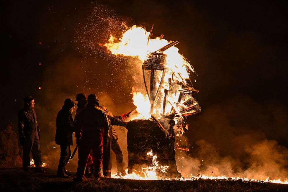 The Clavie, a burning barrel packed with tar-soaked sticks fixed on the top of a pole in Burghead, Scotland
