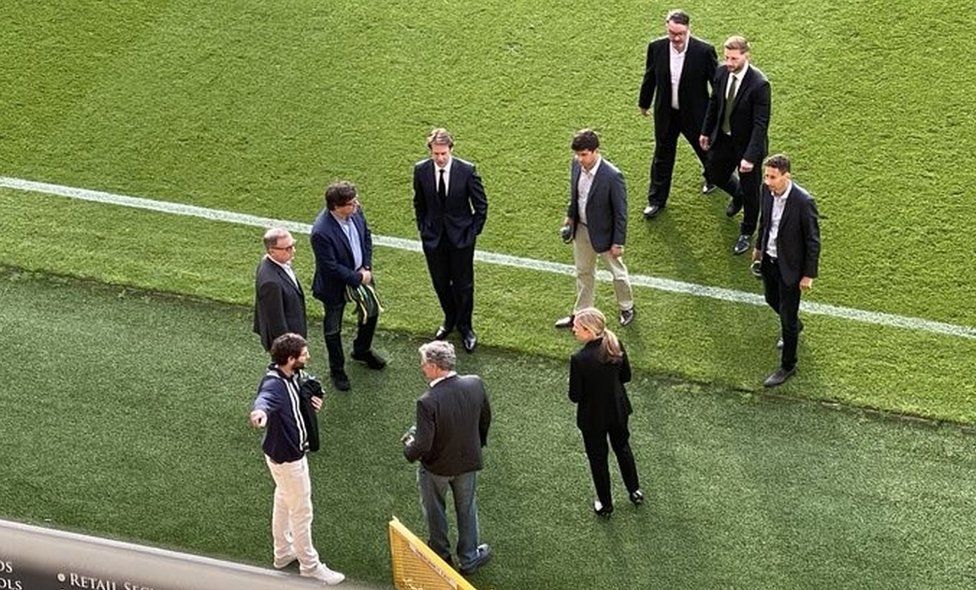 Mark Attanasio and his delegation on the pitch at Norwich City's home ground