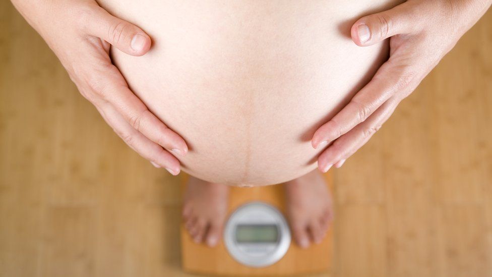 Pregnant woman on scales