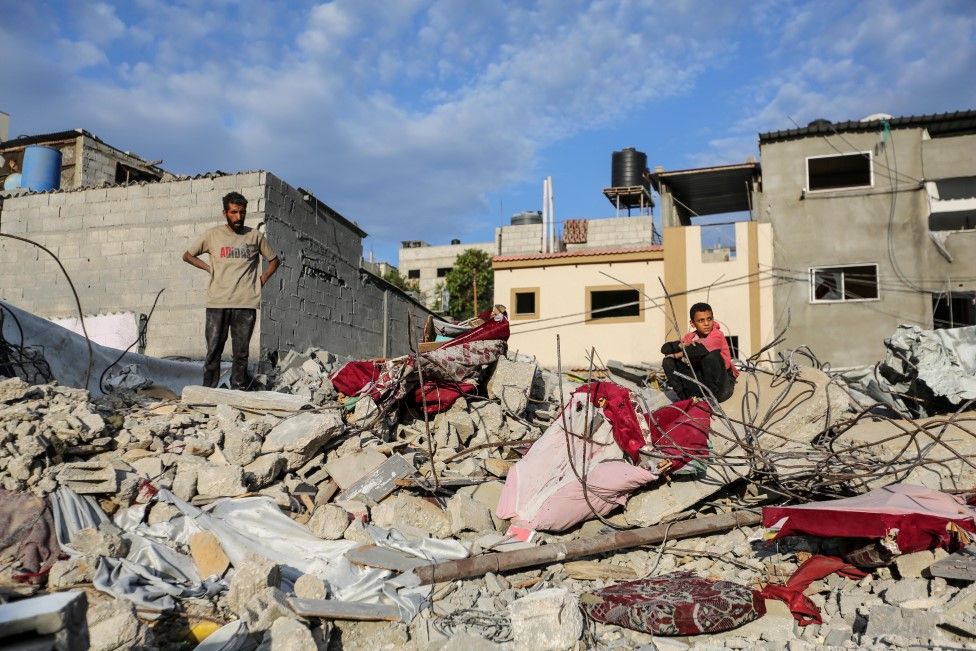 People search through buildings that were destroyed during Israeli air raids in the southern Gaza Strip