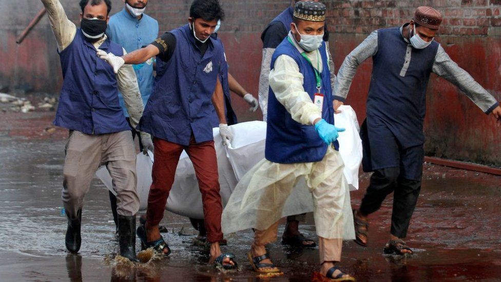 Rescuers carrying a body bag