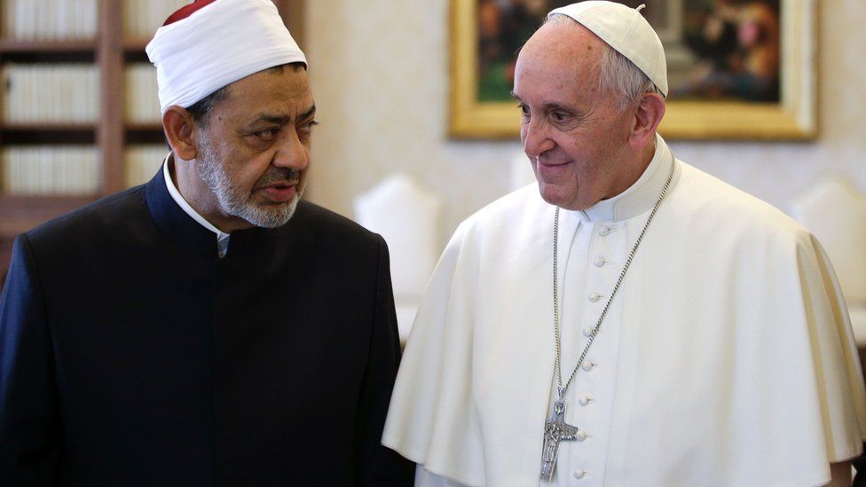 Sheikh al-Tayeb and Pope Francis standing side by side, in conversation