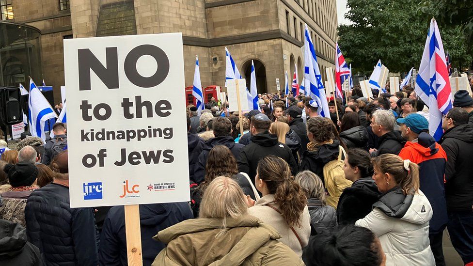 Crowds at a vigil with sign reading No to the kidnapping of Jews