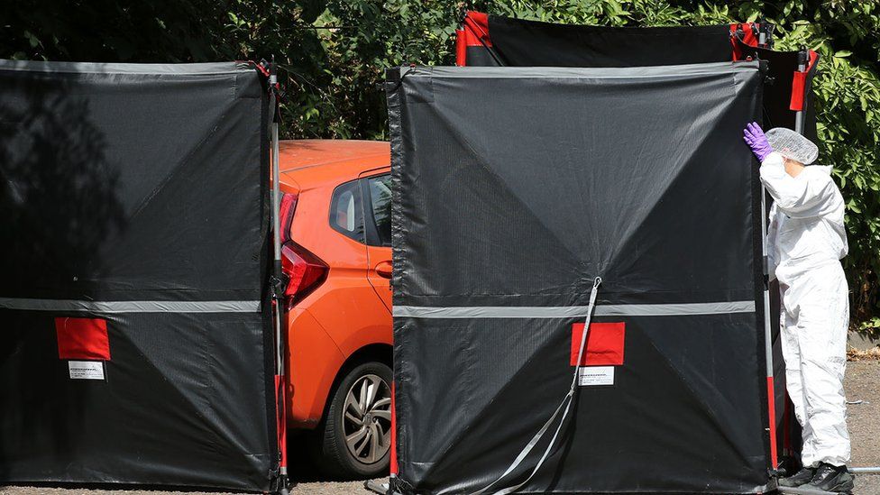 Police forensic officer with car