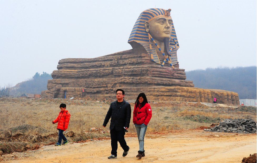 A man, woman and child walk past a full-size replica of the Great Sphinx on 14 March 2015 in Chuzhou, Anhui Province, China.