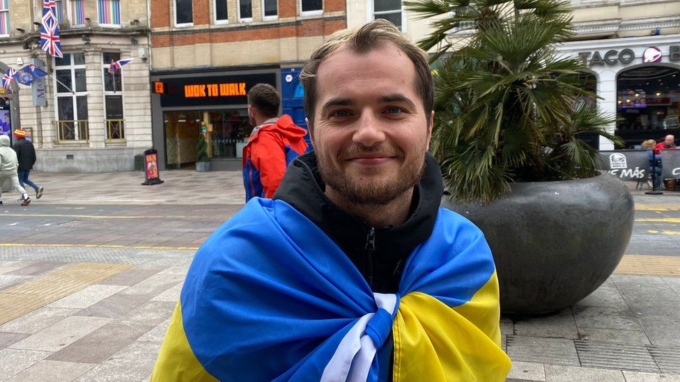 Ukrainian football supporter with flag around him