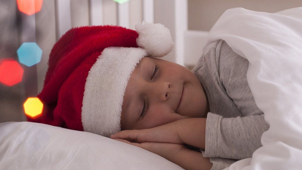 child sleeping in Santa hat