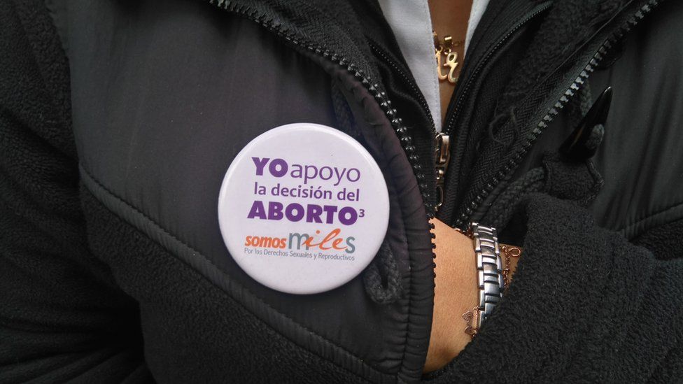 A woman wears a button reading "I back the abortion decision"