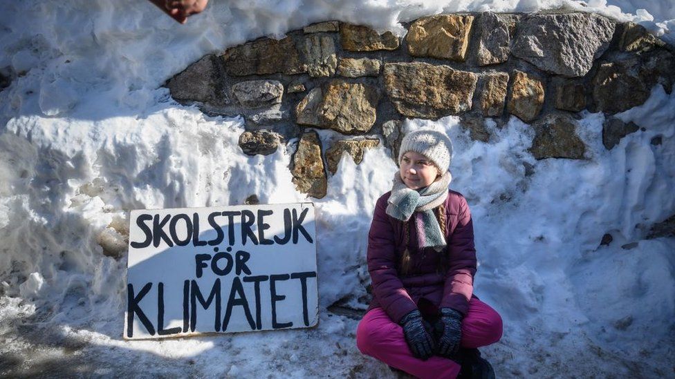 Greta Thunberg and banner at Davos