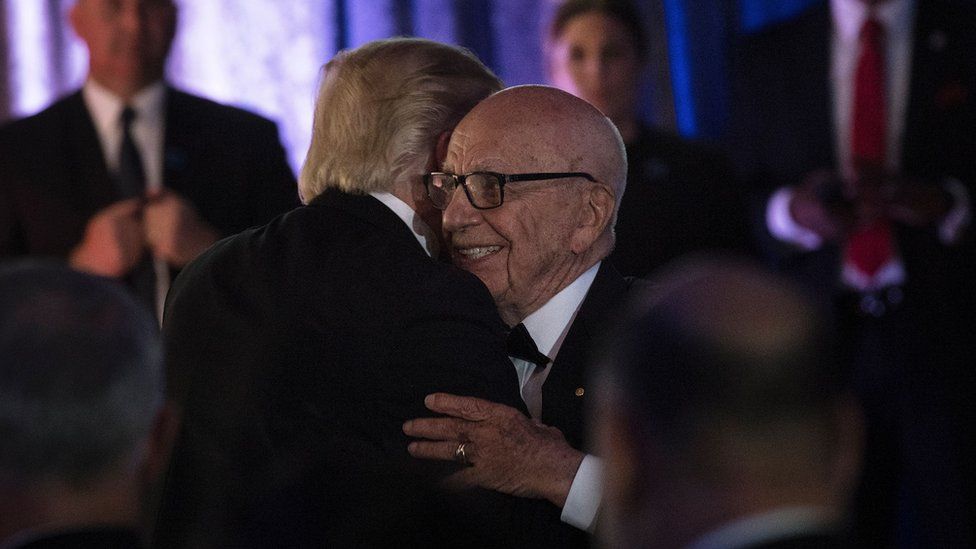 US President Donald Trump (L) is embraced by Rupert Murdoch, Executive Chairman of News Corp, during a dinner to commemorate the 75th anniversary of the Battle of the Coral Sea during WWII onboard the Intrepid Sea, Air and Space Museum May 4, 2017 in New York, New York.
