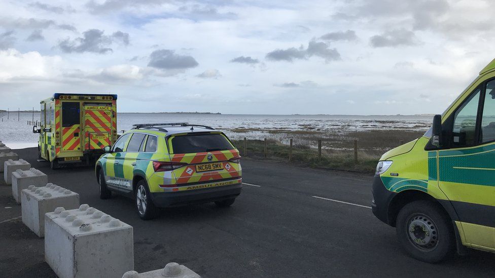 Emergency vehicles at the edge of the Holy Island causeway