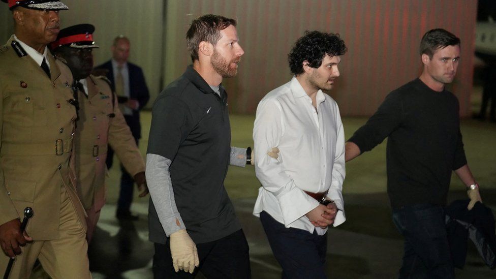 Sam Bankman-Fried is led in handcuffs to a plane in Nassau, 21 December