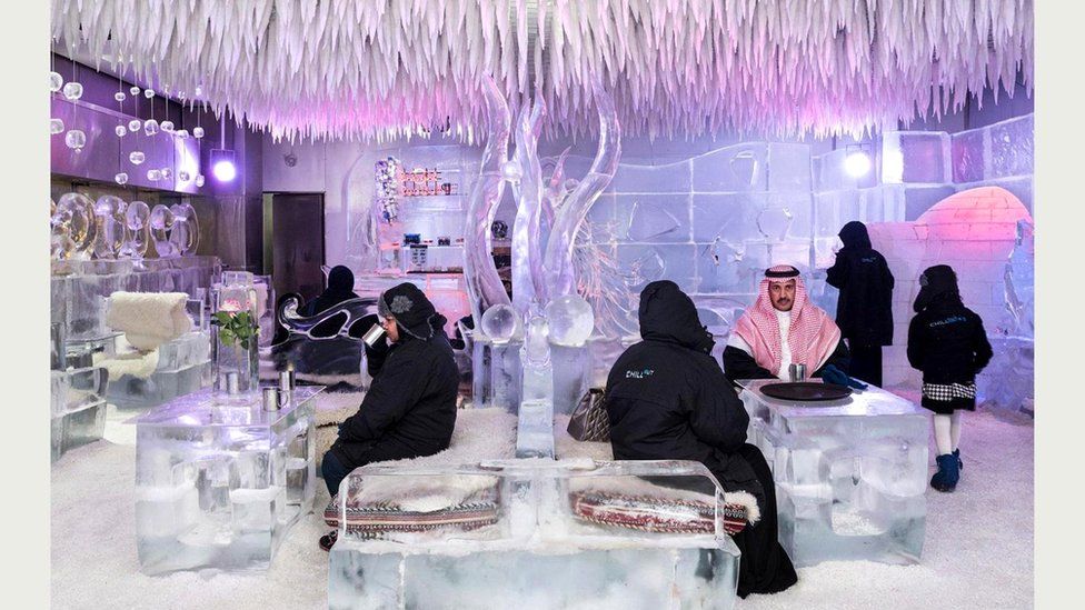 Саудовские туристы согреваются горячим шоколадом в ледяном интерьере Chillout Ice Lounge ("Зал ледяного расслабления"), где температура ниже нуля. Ближний Восток, 6 января 2016 г.