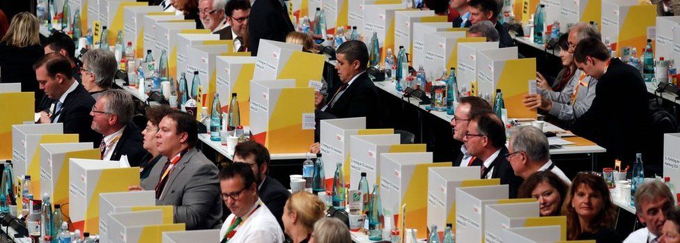 Delegates vote behind portable cardboard voting cabins during a congress of Germany's conservative Christian Democratic Union (CDU) party on December 7, 2018 at a fair hall in Hamburg