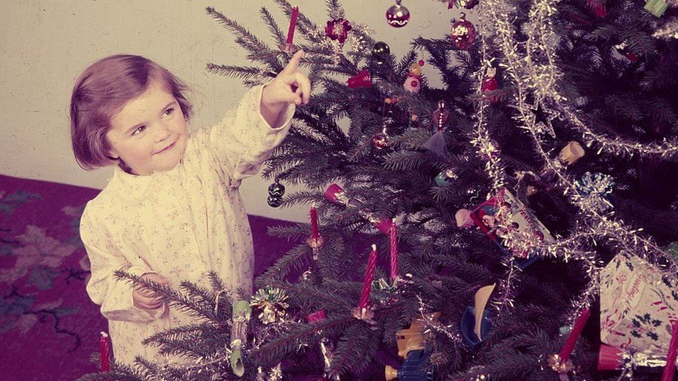 Girl looking at Christmas tree in the 1950s