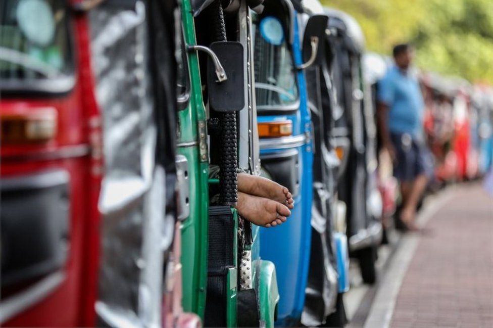 Auto-rickshaw drivers wait in a queue to get fuel from a gas station amid a fuel shortage in Colombo, Sri Lanka, 27 June 2022.