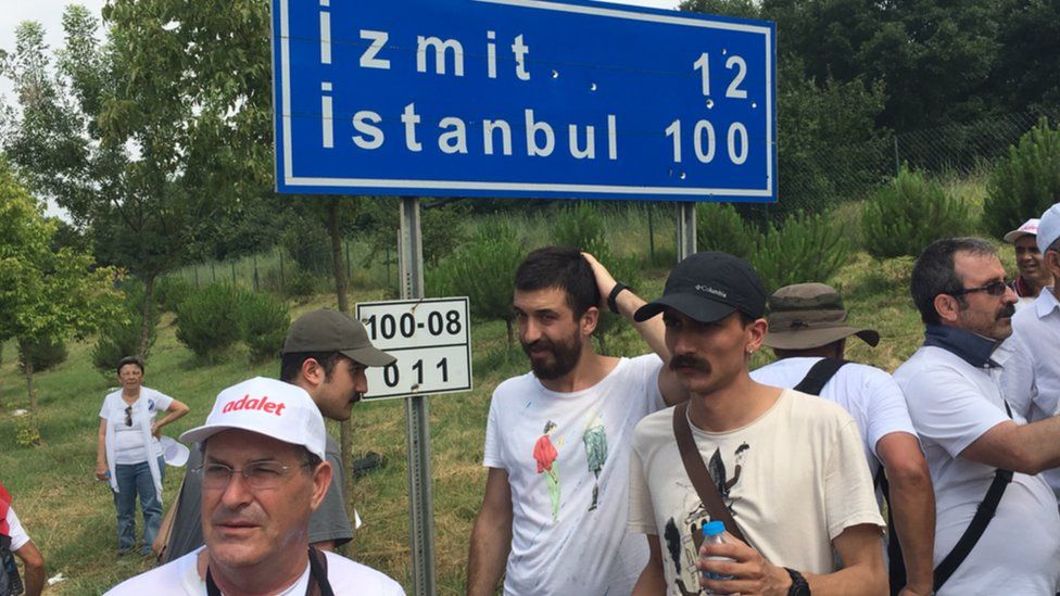 Marchers beneath a sign to Istanbul