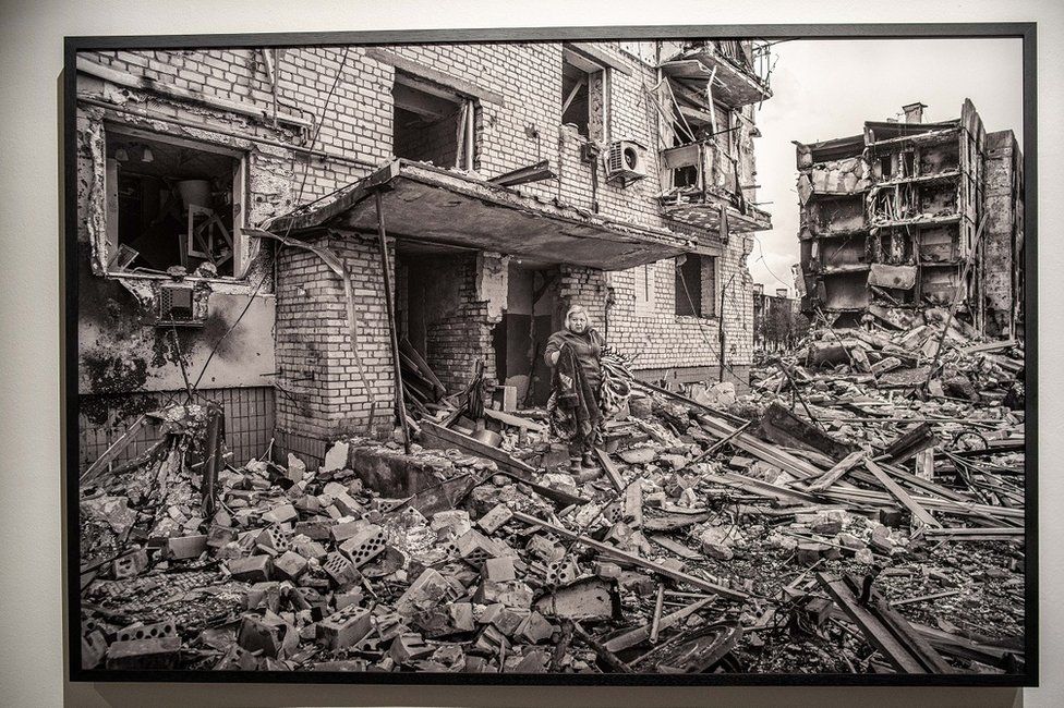 A photo on display of a woman emerging from a smashed apartment block on the outskirts of Kiev in April 2022