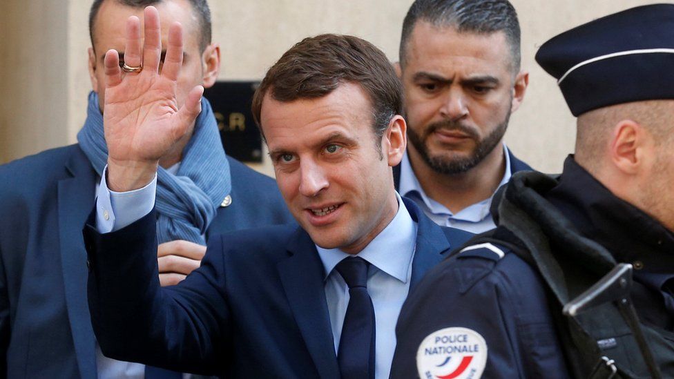 Emmanuel Macron waves to supporters on 24 April