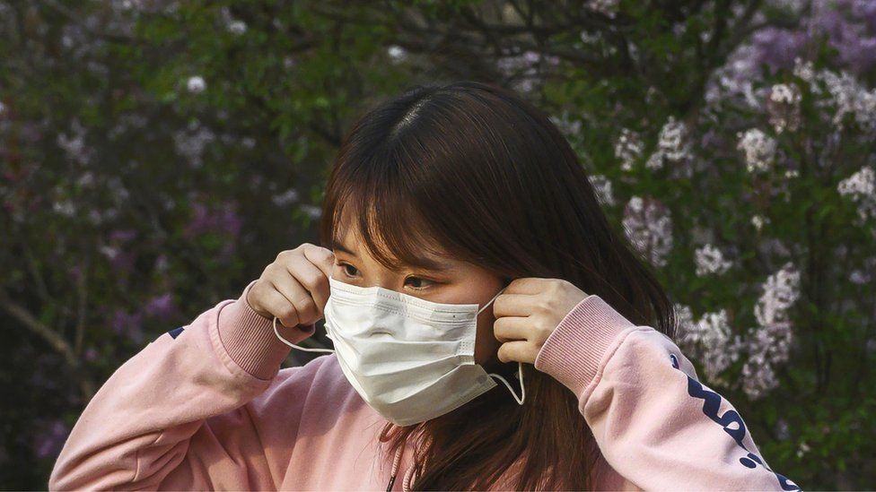 Woman putting face mask