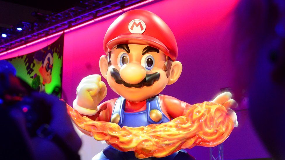 A large figure of Mario wielding a fireball in front of a stage