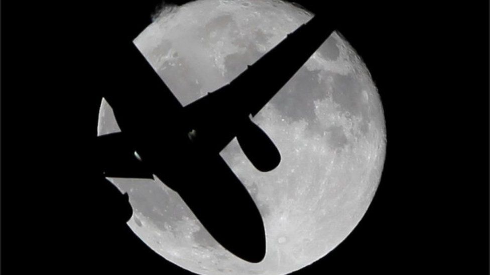 Aircraft in front of moon
