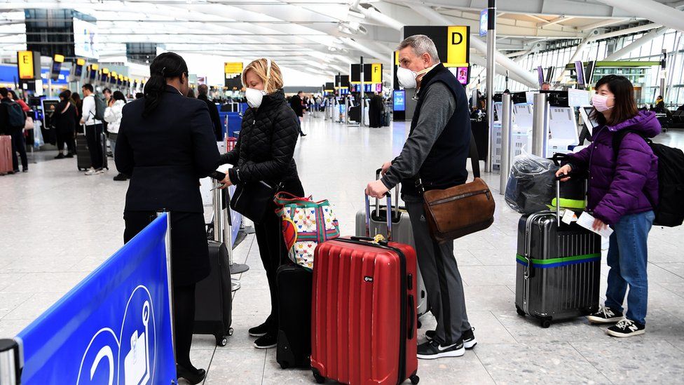 Travellers queue up for flights at Heathrow Airport in London, Britain, 14 March 2020.