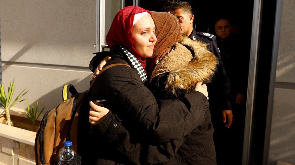 Two Palestinian women hugging in the sunshine