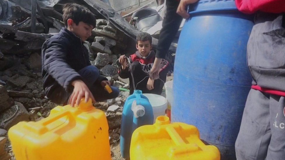 Children with water canisters in Jabalia