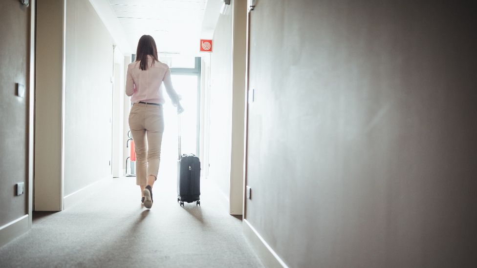 Woman with suitcase in hotel