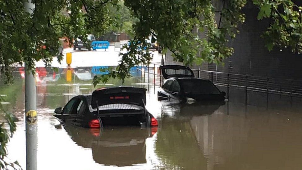 two cars stuck on flooded road