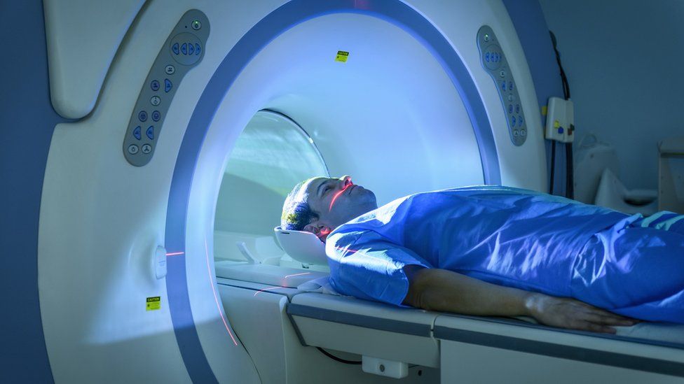 A stock image of a man going through an MRI scanner