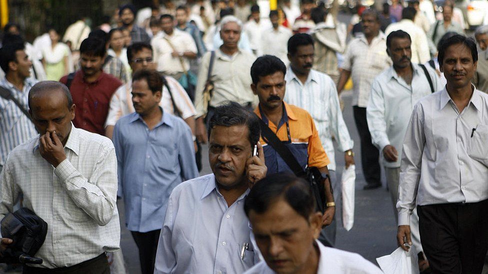 Indian pedestrians walk along the roadside in the busy streets of Mumbai, 10 August 2007. The nation of 1.1 billion people -- marking 60 years since the subcontinent was partitioned on 14-15 August 1947 and independence from British rule-- proudly sees itself well on the road to economic, political and social greatness.