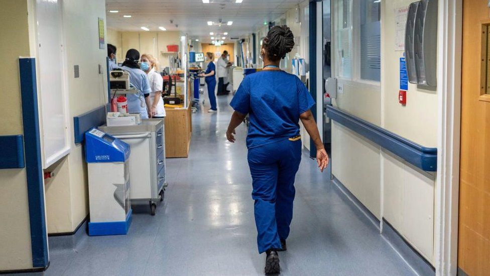 A nurse walking down a hospital corridor