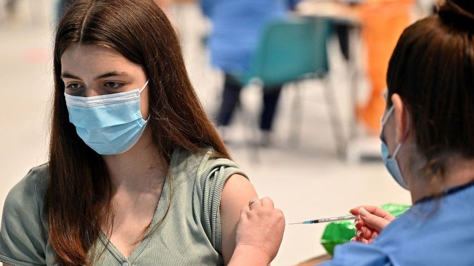 Teenager Katie Moore receives a covid-19 vaccine at a vaccination centre in Barrhead, south of Glasgow on August 9, 2021,