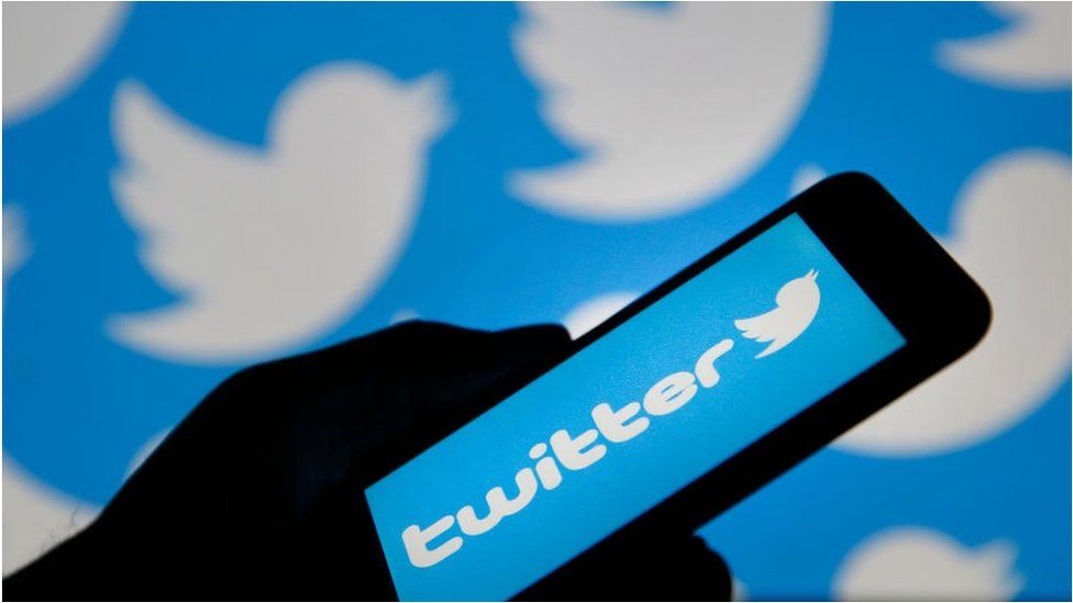 hand holding phone with Twitter open
