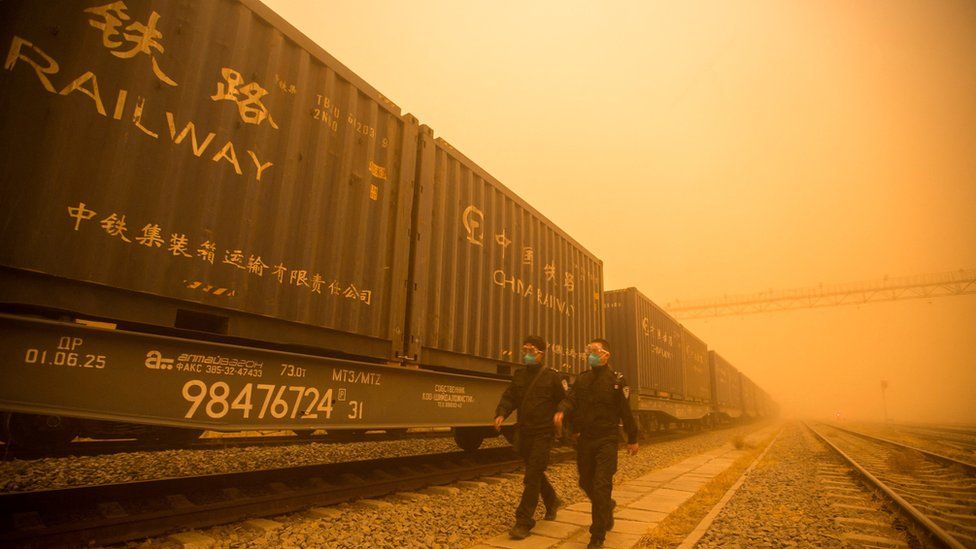 Yellow dust from sandstorms blanket container vans in Inner Mongolia.