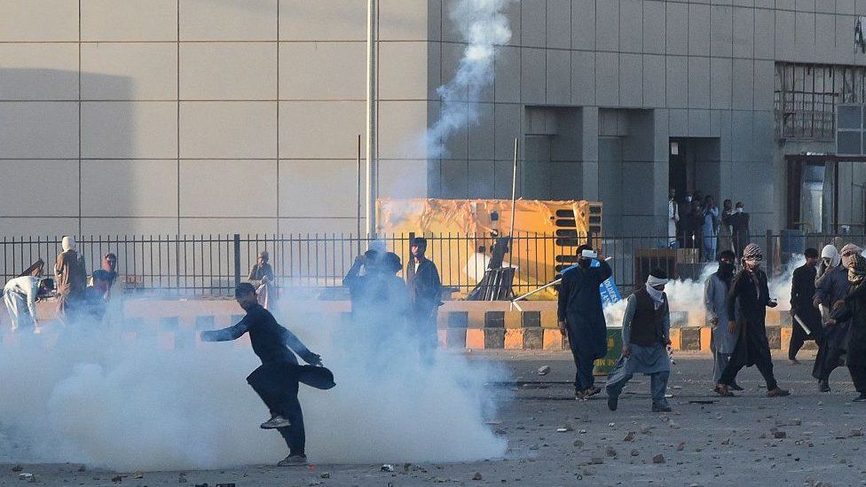 A Pakistan Tehreek-e-Insaf (PTI) party activist and supporter of former Pakistan's Prime Minister Imran throws back a tear gas shell towards police during a protest against the arrest of their leader, in Quetta on May 9, 2023.