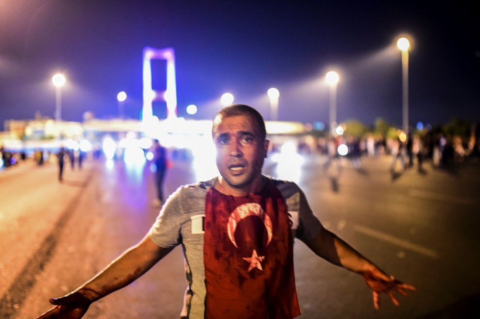 A man covered with blood stands near the Bosphorus bridge as Turkish military clash with people at the entrance to the bridge in Istanbul on 16 July 2016