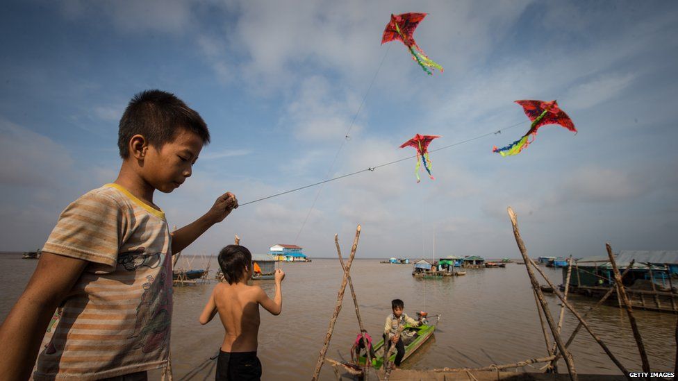 Children play with kites on the floating village on May 13, 2015 on Tonle Sap Lake, Cambodia