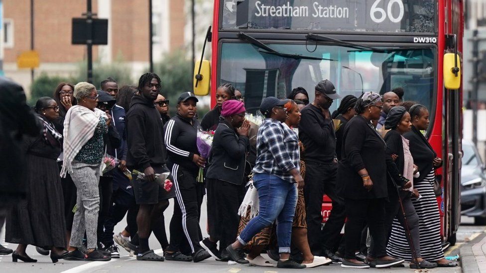 Family members and friends gathering in a group of more than 20 people on Wellesley Road.