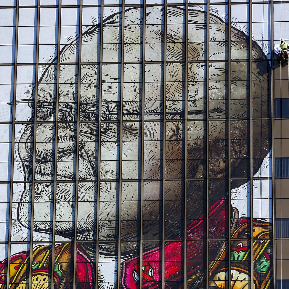 Workers in Cape Town install a giant image of Desmond Tutu, South Africa's Nobel Peace laureate, a celebration of his dedication to society.