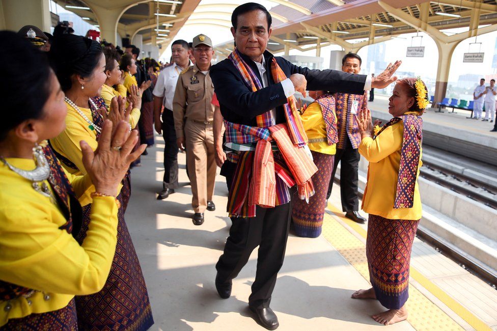Thailand's Prime Minister Prayuth Chan-ocha performs a traditional dance with performers at Khon Kaen railway station