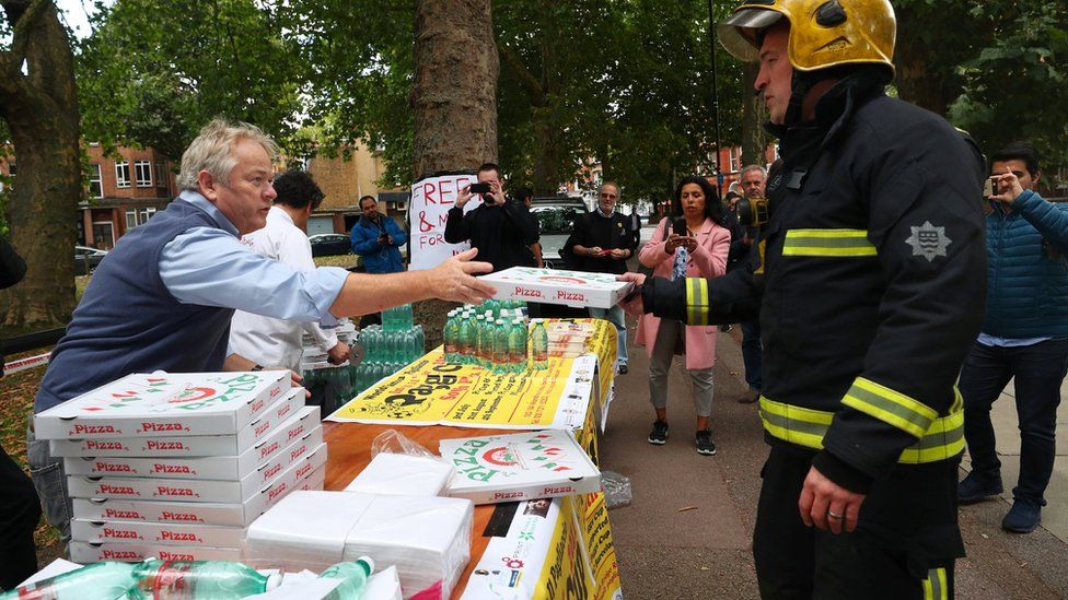 Pizzas and water being handed out