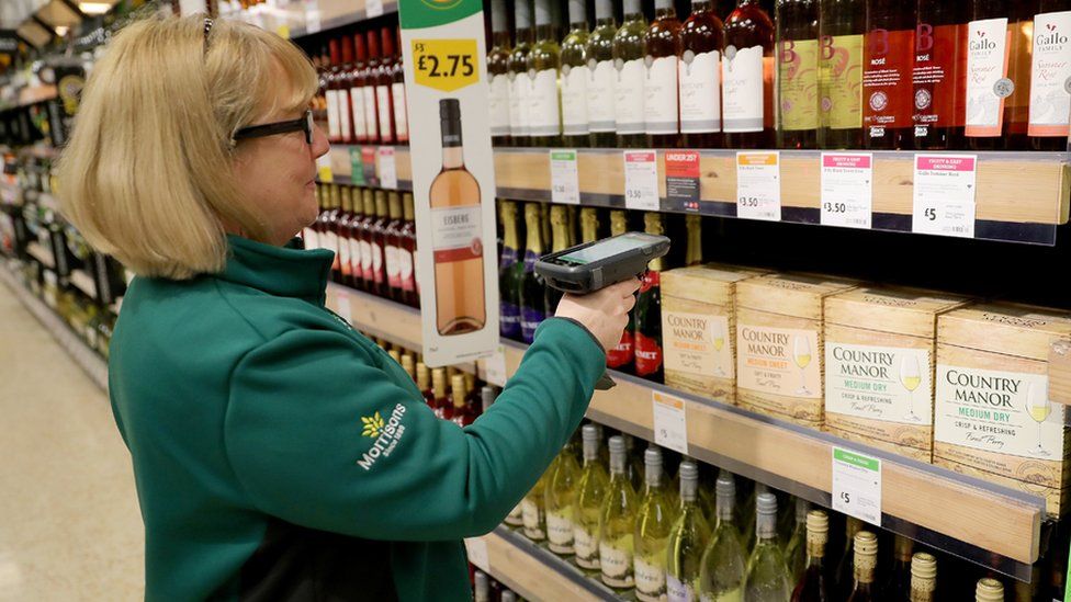 A member of staff scans groceries inside a Morrisons supermarket