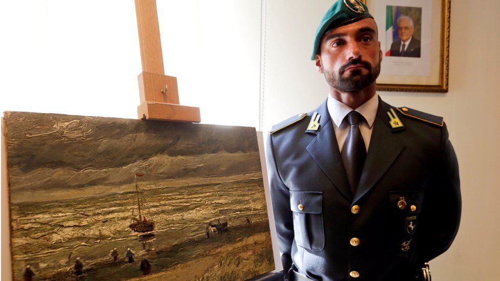 A guard stands to attention next to one of the Van Gogh paintings