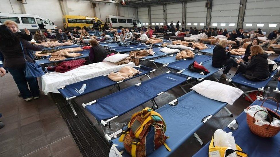 People rest on camp beds in an accommodation centre for the victims of the earthquake (27 October 2016)